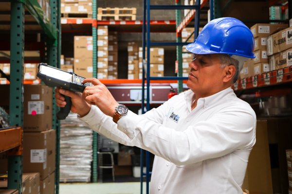 Especialista de Hand Held Solutions escaneando mercancía con una handheld en almacén